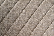 Nahaufnahme des beige strukturierten Stoffes eines Drehstuhlsitzes in diagonaler Perspektive