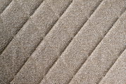 Nahaufnahme des beige strukturierten Stoffes eines Drehstuhlsitzes in diagonaler Perspektive