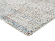 Frisé-Teppich in Nahaufnahme, zeigt eine bunte, strukturierte Oberfläche mit einem Mix aus Blau-, Rot- und Gelbtönen. Perspektive von der Seite.