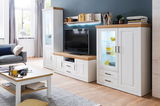 Wohnzimmeransicht mit der Wandkombination BREGENZ in heller Holzoptik, bestehend aus einem TV-Schrank, zwei Vitrinen und einem Wandregal. Die Perspektive zeigt die Möbel von vorne in einem modernen, hellen Raum.
