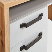 Nahaufnahme eines Schreibtisches mit zwei weißen Schubladen und schwarzen Griffen, seitliche Perspektive