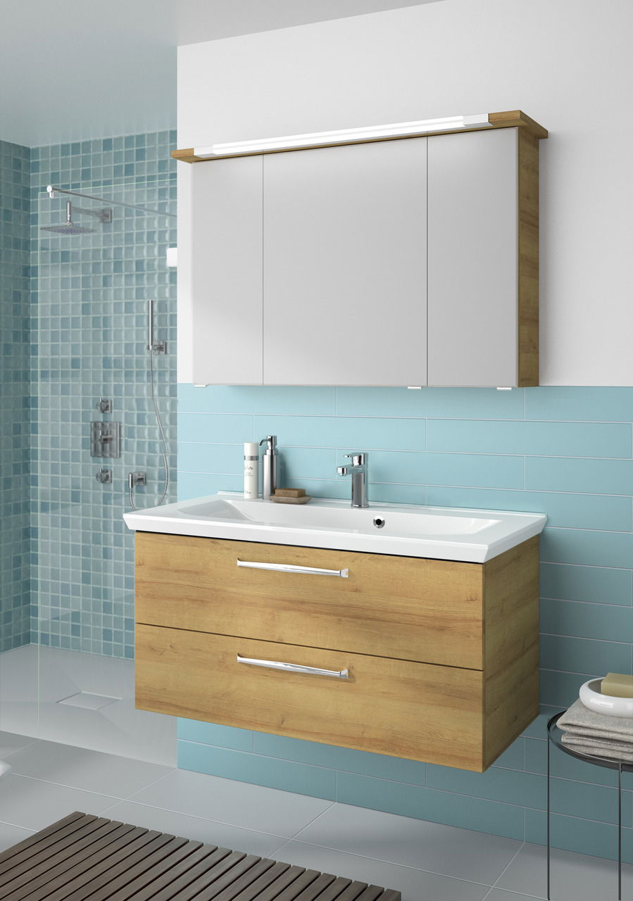 Moderner Badblock mit Holzoptik und weißem Waschbecken, frontal betrachtet, vor einer Wand mit blauen Fliesen.