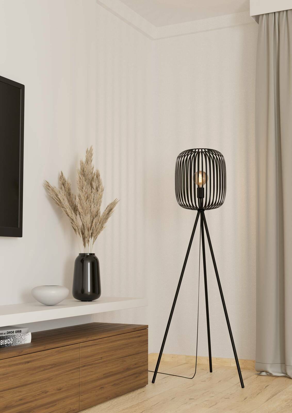 Moderne Stehleuchte ROMAZZINA mit schwarzem, dreibeinigem Gestell und offenem Lampenschirm aus Metallstreben, seitliche Perspektive im Wohnzimmer.