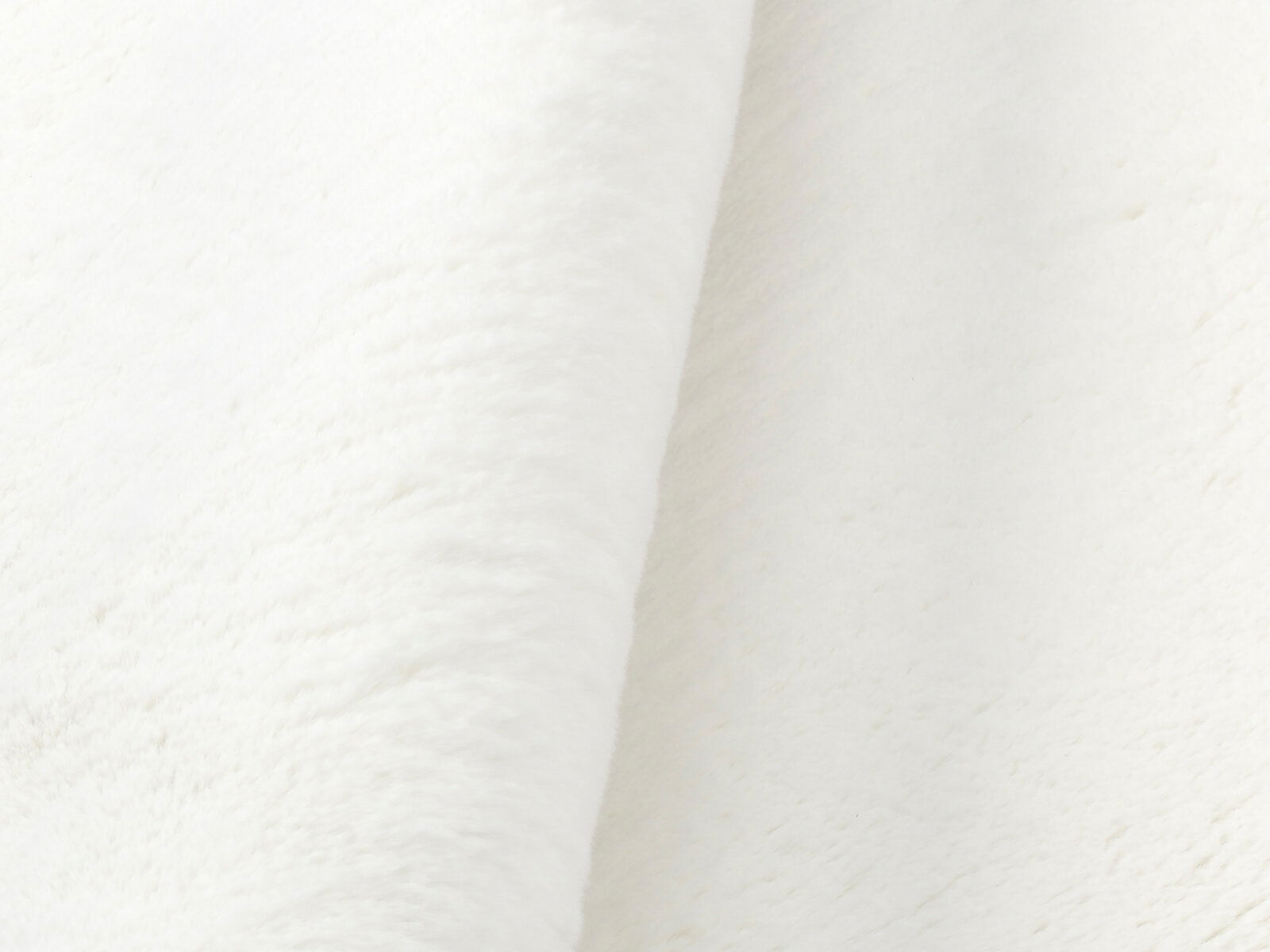 Nahaufnahme eines weißen Fellteppichs in seitlicher Perspektive