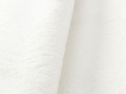 Nahaufnahme eines weißen Fellteppichs in seitlicher Perspektive