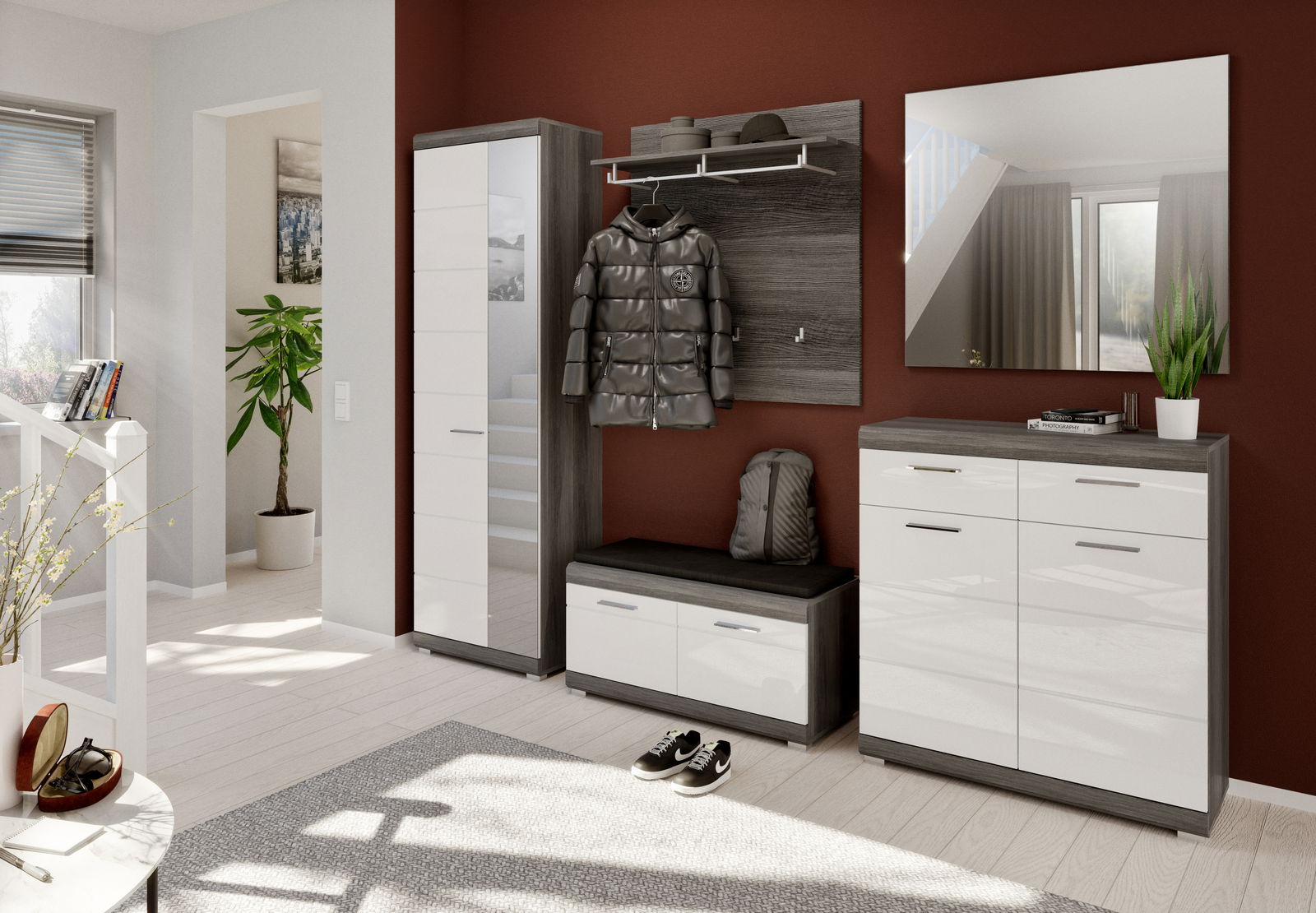 Moderne Garderobeneinrichtung mit Schuhschrank, Garderobenschrank, Spiegel und Sitzbank in einem hellen Raum mit roter Akzentwand, aus der Perspektive des Eingangsbereichs betrachtet.