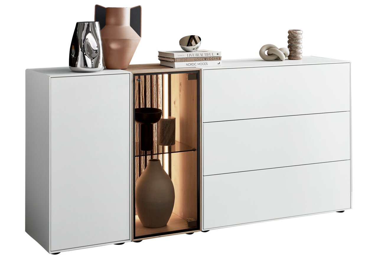 Modernes Sideboard mit Glasvitrine links, dekoriert mit Vasen und Büchern, aus einer frontalen Perspektive.