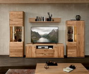 Wohnzimmer-Wohnwand aus hellem Massivholz mit TV-Lowboard, zwei Vitrinenschränken mit Beleuchtung und Wandregal, frontal aus Augenhöhe fotografiert