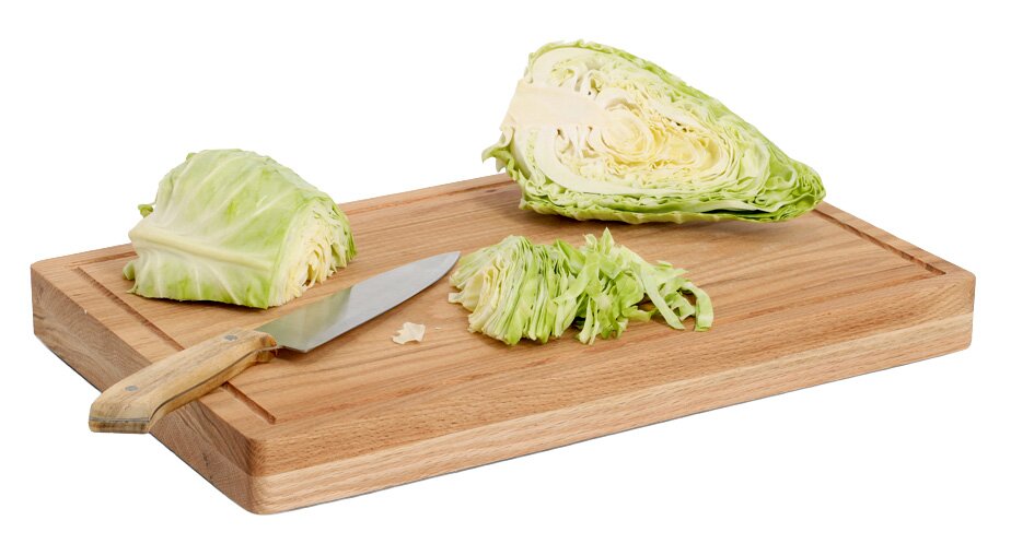Schneidebrett aus Eiche mit geschnittenem Kohl und Messer, seitliche Perspektive.