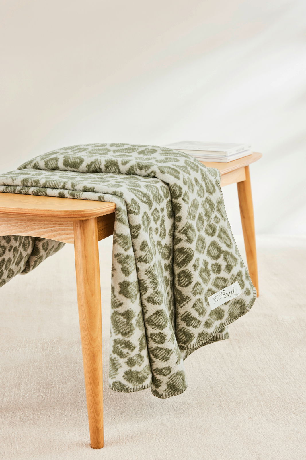 Grüne Wohndecke mit Muster auf einem Holztisch, seitliche Perspektive