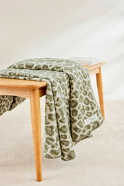 Groene deken met patroon op een houten tafel, zijaanzicht