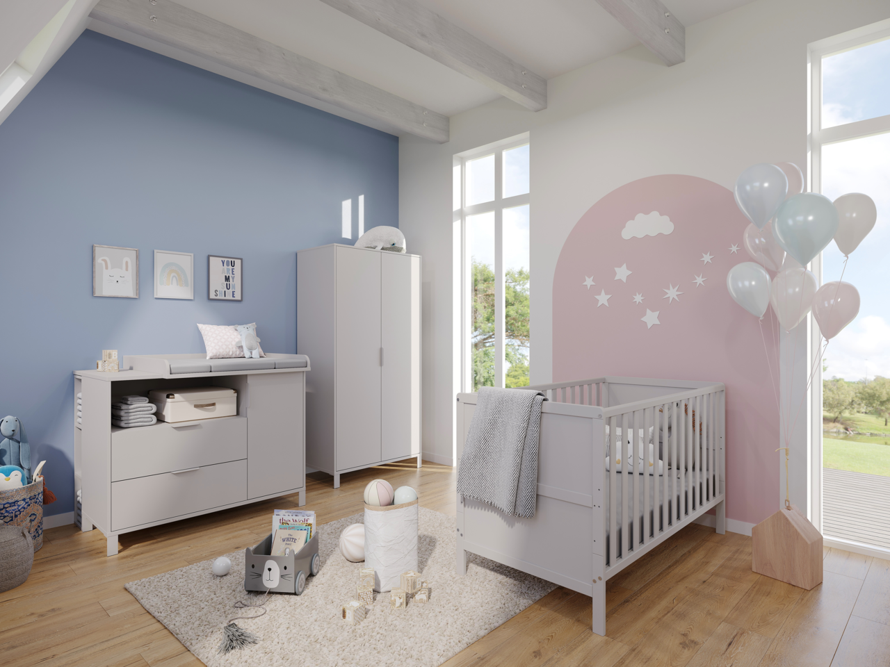 Kinderzimmer mit Wickelkommode, Kleiderschrank und Gitterbett in hellem Holz. Blick von schräg vorne auf die Möbel. Pastellfarbene Wanddekoration und Luftballons ergänzen das freundliche Ambiente.