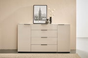 Moderne weiße Hochglanz-Kommode/Sideboard mit zwei Türen und vier mittigen Schubladen, schwarzen Griffleisten und Deko (New-York-Poster, Vasen mit Zweigen) auf der Oberfläche, frontal aus leicht erhöhter Perspektive fotografiert