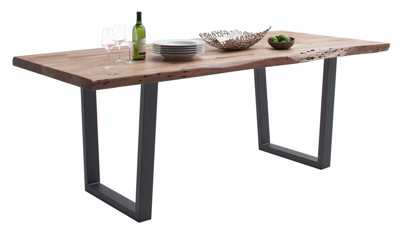 Moderner Esstisch aus Holz mit Metallbeinen, dekoriert mit Geschirr und einer Flasche Wein, seitliche Perspektive
