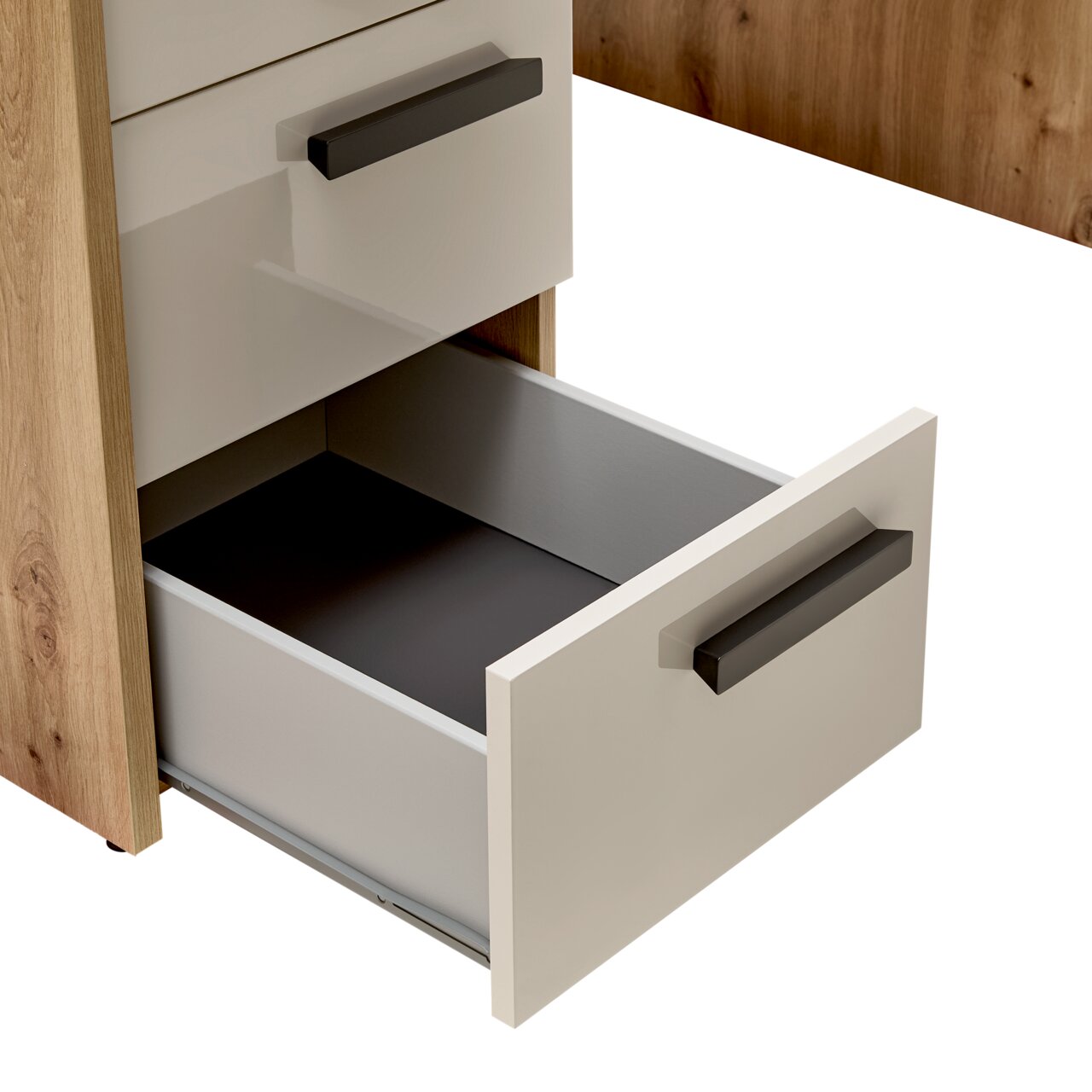 Nahaufnahme eines Schreibtischs mit geöffneter Schublade, Holzoptik mit weißen Fronten und schwarzen Griffen, seitliche Perspektive.