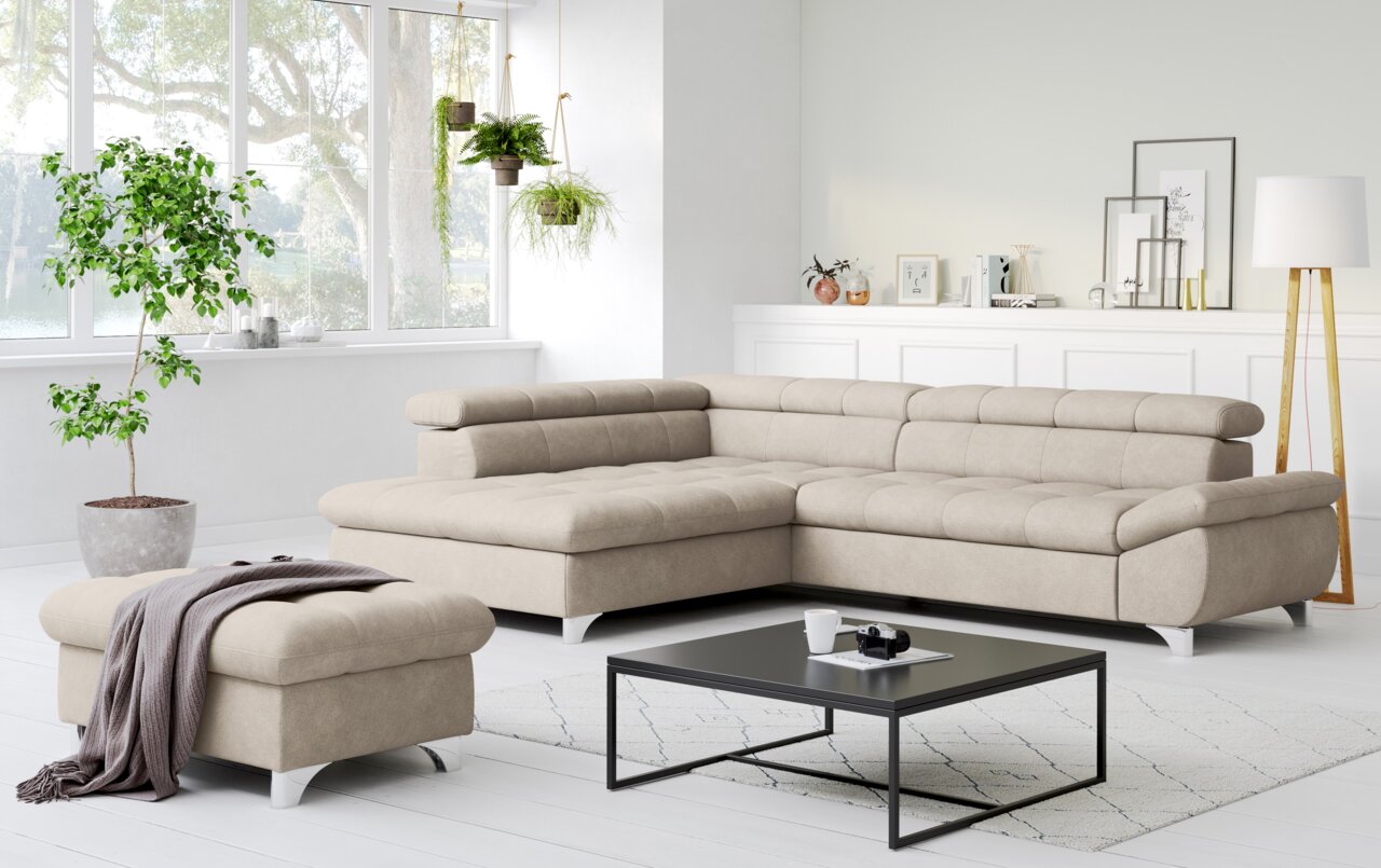 Lounge Handmade Ecksofa GEMINI Modernes beiges L-förmiges Ecksofa mit gepolsterter Rückenlehne und passendem Hocker in hellem Wohnzimmer, Perspektive: frontale 3/4-Ansicht von leicht links.