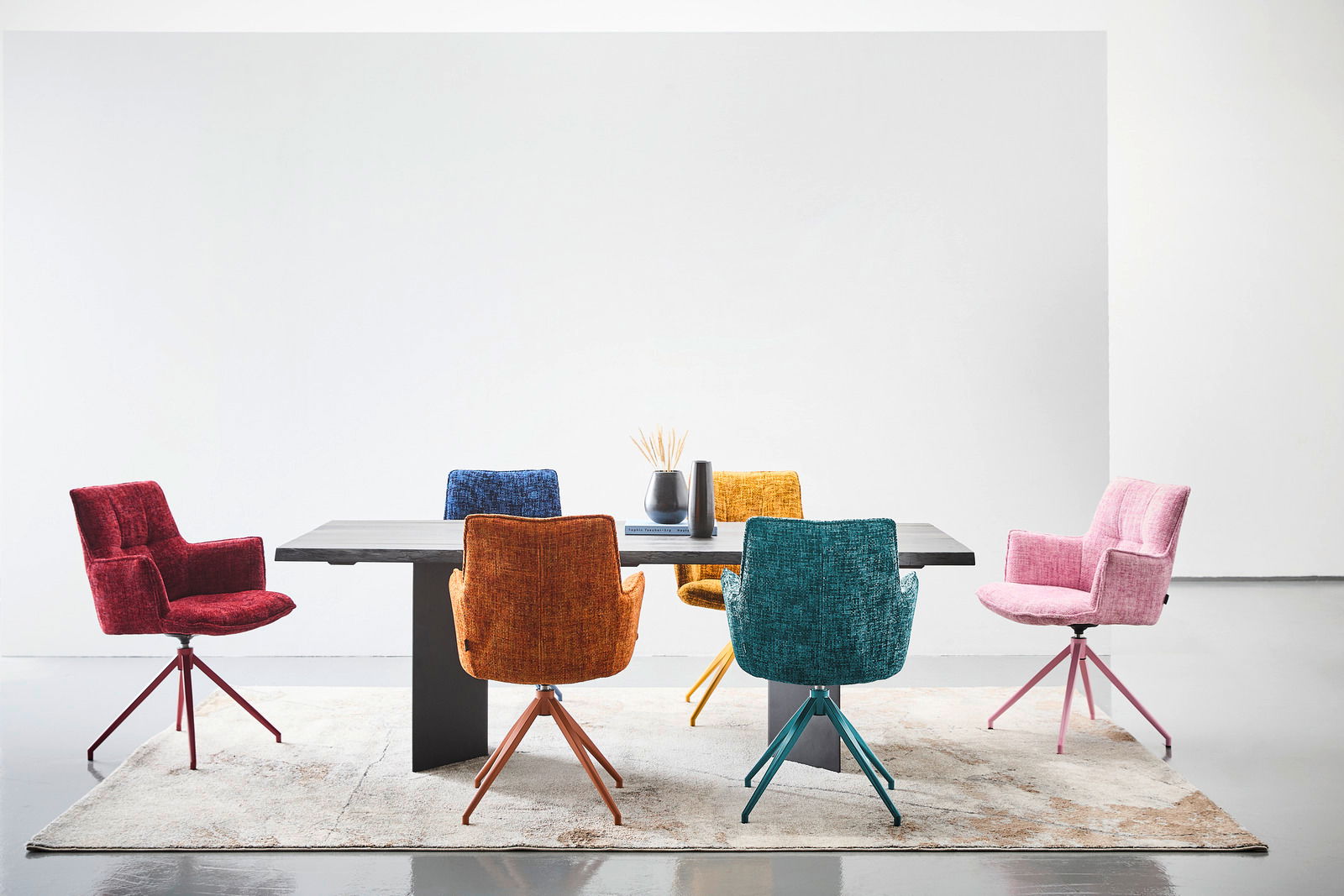 Moderner Esstisch 220x100 cm mit sechs bunten Stühlen, frontal betrachtet.