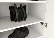 Innenansicht eines weißen Garderobenschranks mit zwei Regalböden, auf denen eine schwarze Tasche und ein schwarzer Hut liegen. Perspektive von schräg vorne.