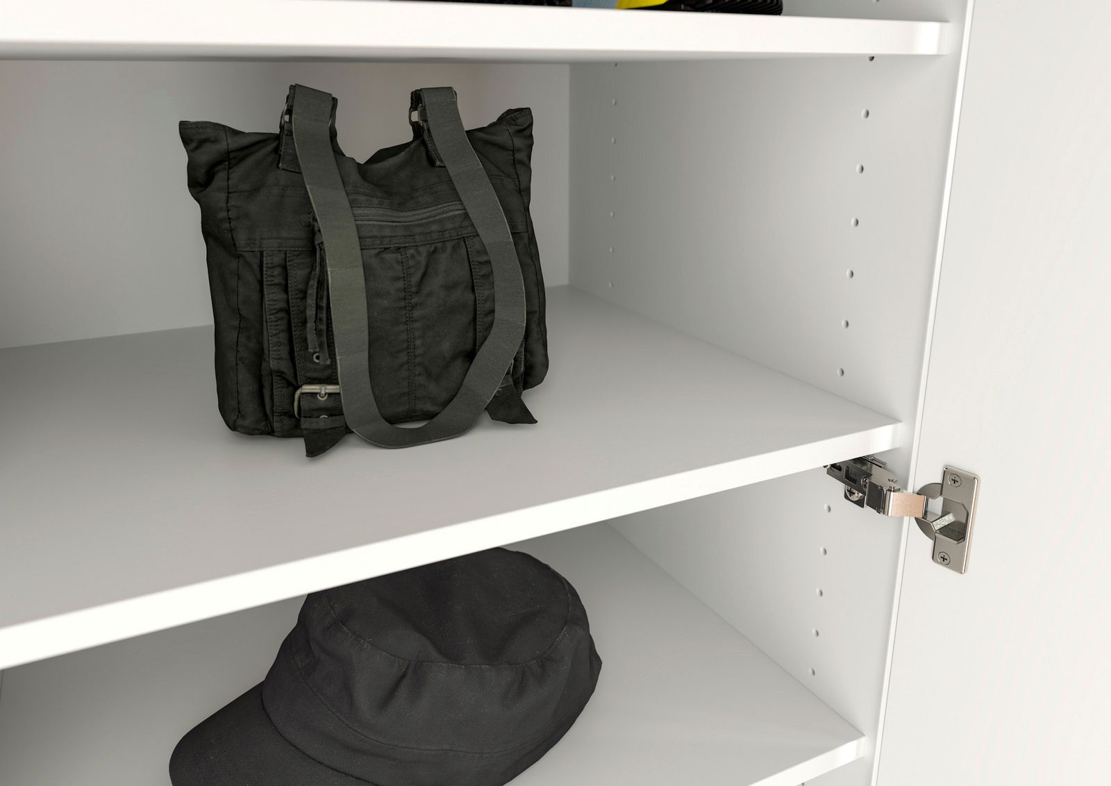 Innenansicht eines weißen Garderobenschranks mit zwei Regalböden, auf denen eine schwarze Tasche und ein schwarzer Hut liegen. Perspektive von schräg vorne.