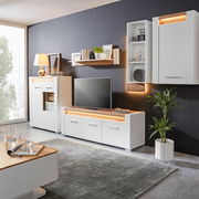 Modernes Wohnzimmer mit weißem TV-Unterteil, umgeben von stilvollen Möbeln und Dekorationen, seitliche Perspektive.