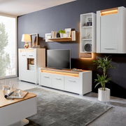 Modernes Wohnzimmer mit weißem TV-Unterteil, umgeben von stilvollen Möbeln und Dekorationen, seitliche Perspektive.