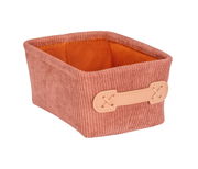 Rechteckiger Badkorb Anela mini in einem warmen Rostton, aus geripptem Stoff mit einem hellen Griffdetail an der Seite. Perspektive: leicht von oben und seitlich.