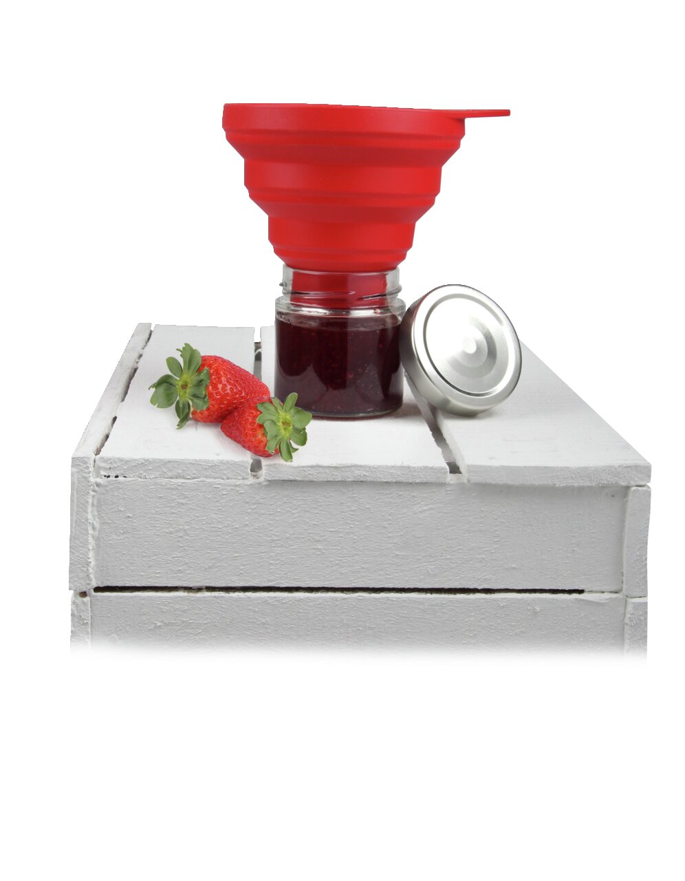 Roter Silikon-Einmachtrichter Flexxi auf einem Glas mit Marmelade, daneben ein Deckel und Erdbeeren, seitliche Perspektive.