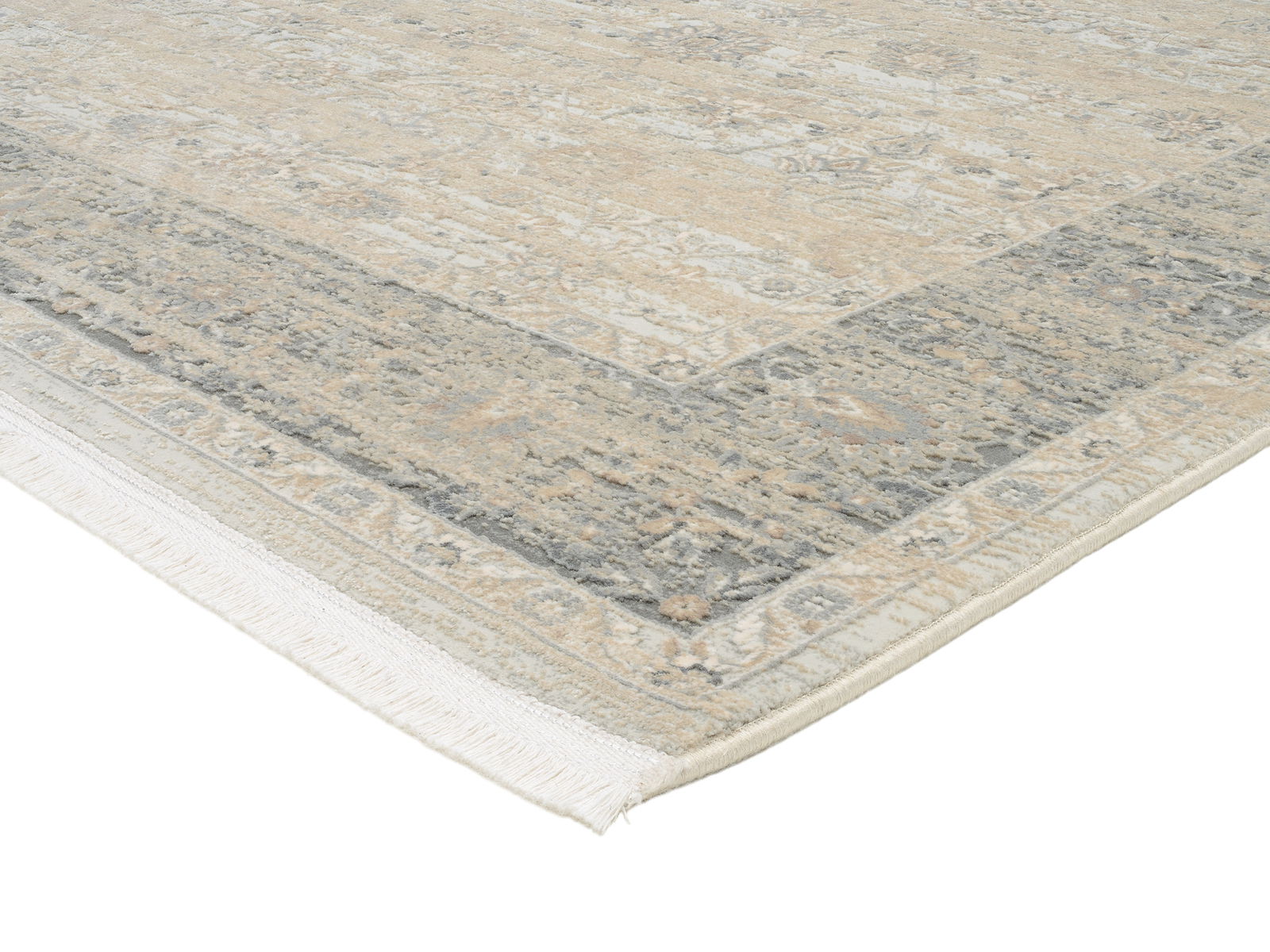 Designer Teppich in Beige- und Grautönen mit Fransen, perspektivisch von der Ecke aufgenommen.