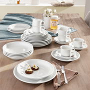 Kombiservice Trend weiß 30-tlg auf einem Tisch arrangiert, mit Tellern, Tassen und Besteck, aus einer leicht erhöhten Perspektive fotografiert.
