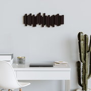 Moderne Wandgarderobe in dunklem Holzdesign, horizontal an einer hellen Wand über einem Schreibtisch mit Kaktus und Büromaterialien angebracht, seitliche Perspektive.
