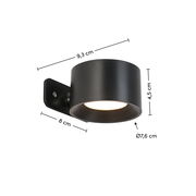 Schwarze Akku-Wandleuchte mit zylindrischem Design, seitliche Perspektive, Maße: 9,3 cm Länge, 8 cm Breite, 4,5 cm Höhe, Durchmesser 7,6 cm.