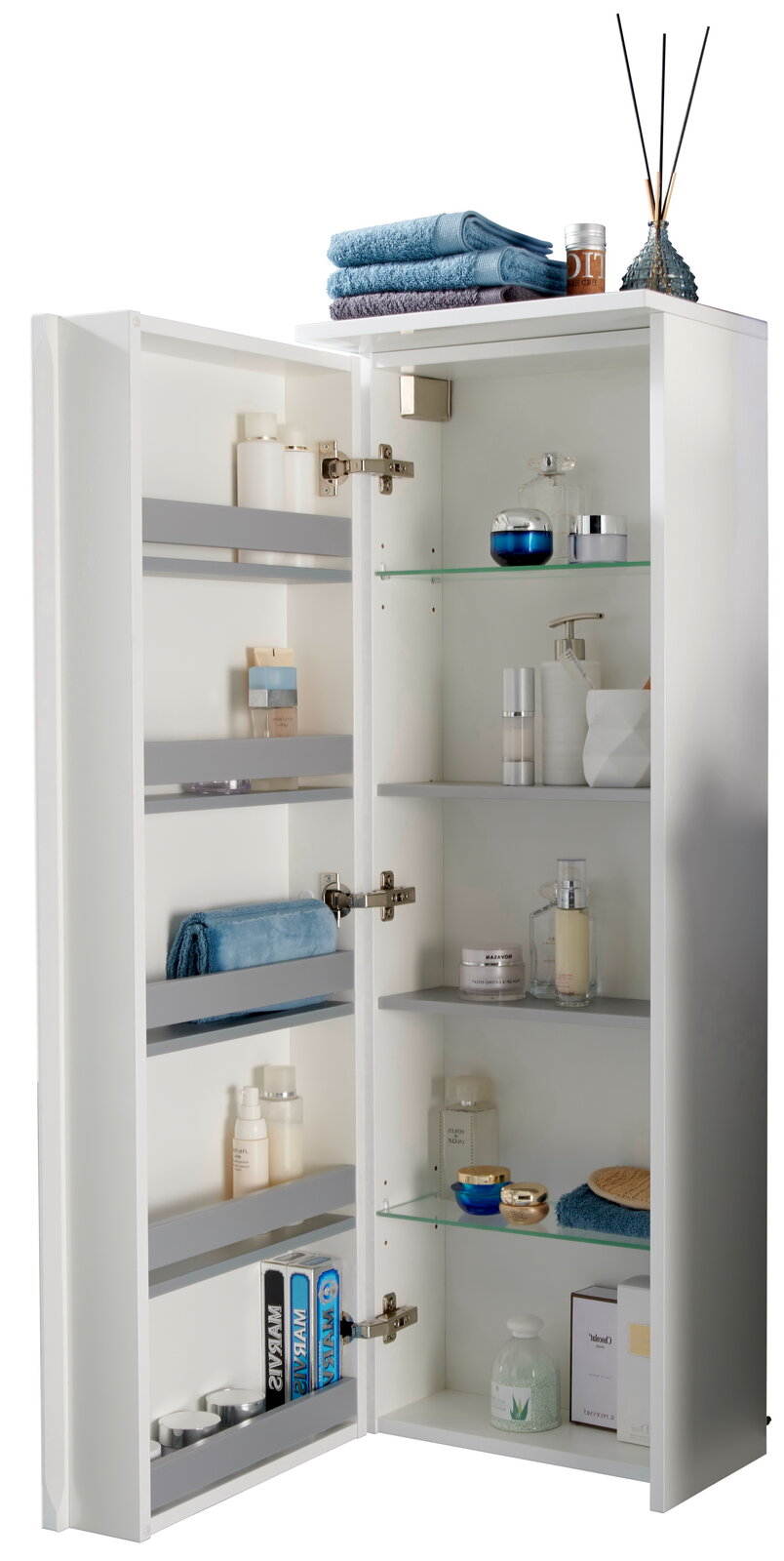 Voleo Kofferschrank links LARA Geöffneter Kofferschrank links mit mehreren Regalen, gefüllt mit Handtüchern, Pflegeprodukten und Dekorationen, aus einer leicht seitlichen Perspektive fotografiert.