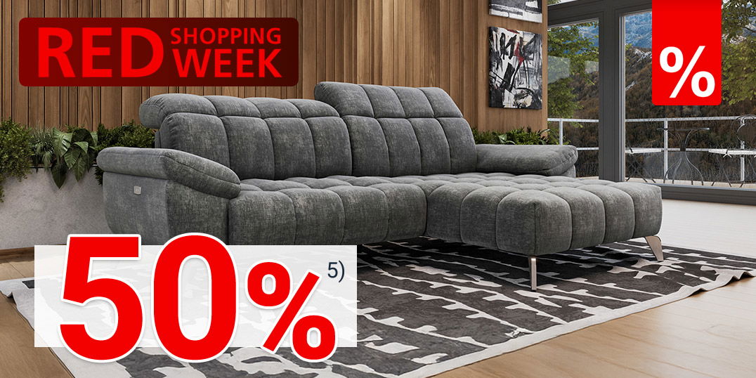Modernes Wohnzimmer mit grauem Sofa, Holzpaneelwand, Teppich, großen Fenstern und rotem „Red Shopping Week“-Banner
