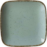 Vogelperspektive auf einen quadratischen, blauen Beilagenteller mit gesprenkeltem Muster und rustikalem Rand.