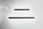 Zwei moderne LED-Außenwandleuchten in rechteckiger Form, an einer weißen Wand montiert, aus der Frontalperspektive betrachtet.