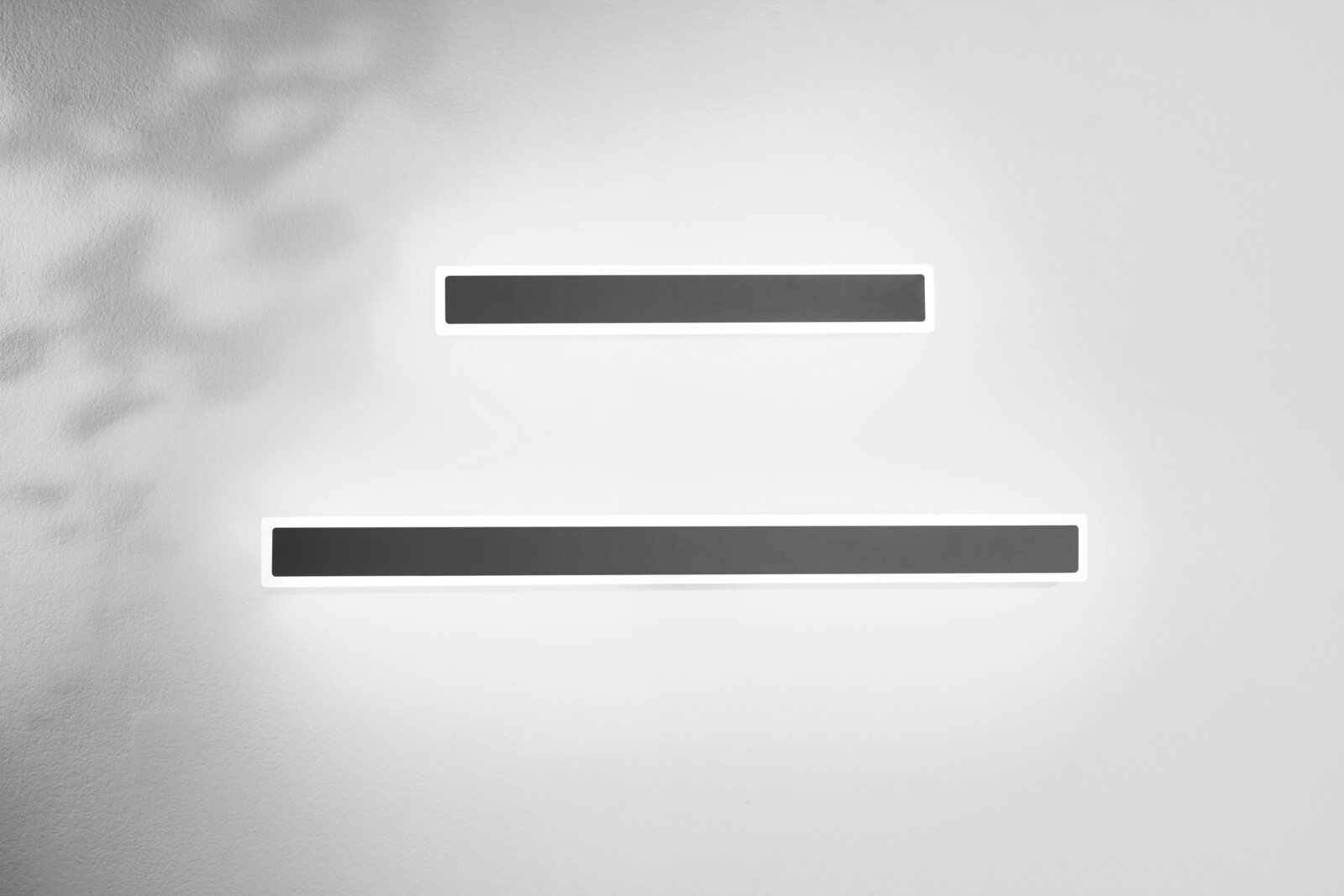 Zwei moderne LED-Außenwandleuchten in rechteckiger Form, an einer weißen Wand montiert, aus der Frontalperspektive betrachtet.