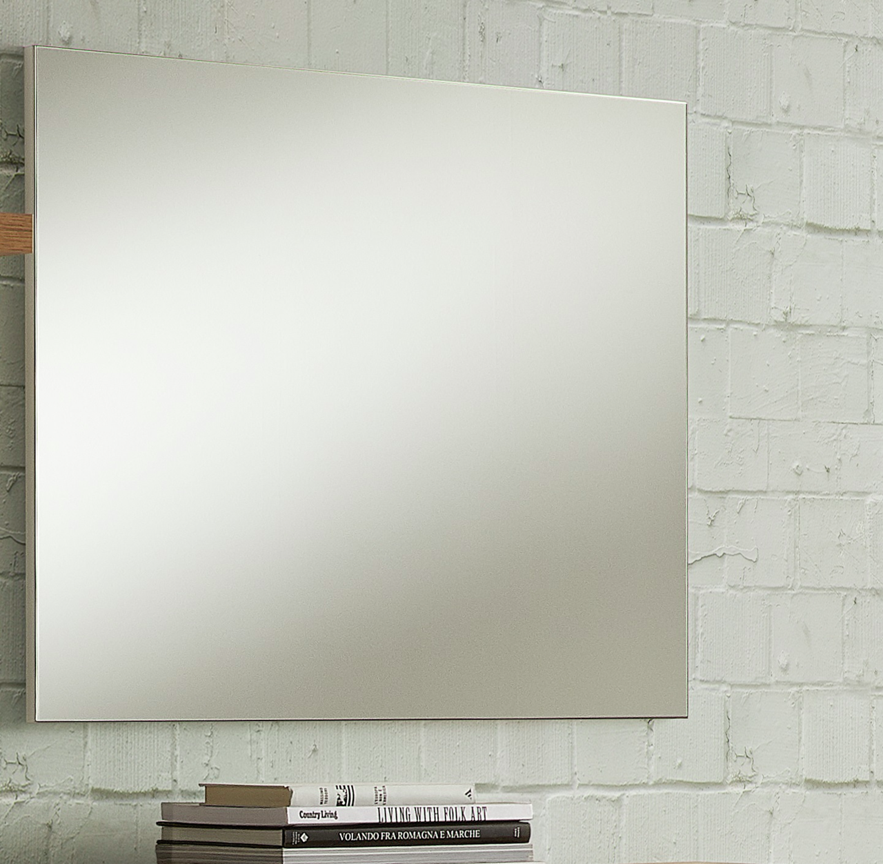 Rechteckiger Wandspiegel vor einer weißen Ziegelwand, seitliche Perspektive