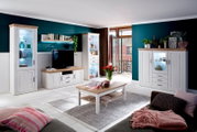 Moderne woonkamer met een witte wandmeubelcombinatie en vitrinekasten met houten blad, tv-meubel, dressoir en salontafel op een lichte vloer, gefotografeerd van voren vanuit een licht schuin groothoekperspectief