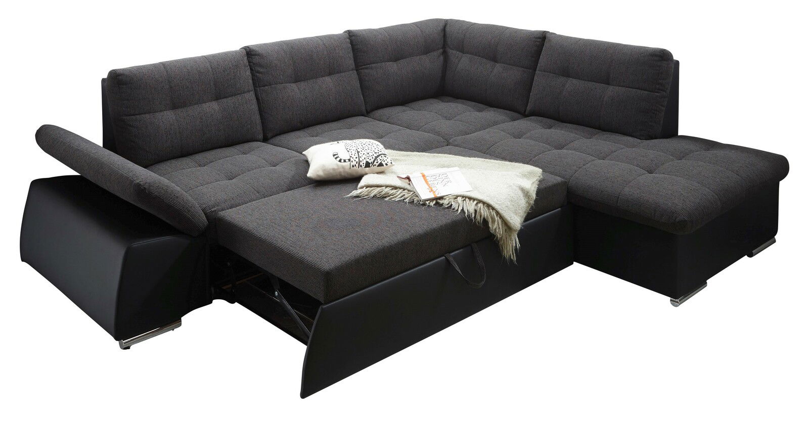 Ecksofa mit dunkelgrauem Stoffbezug, ausgezogen zu einem Bett, mit Kissen und Decke, Perspektive von schräg vorne.