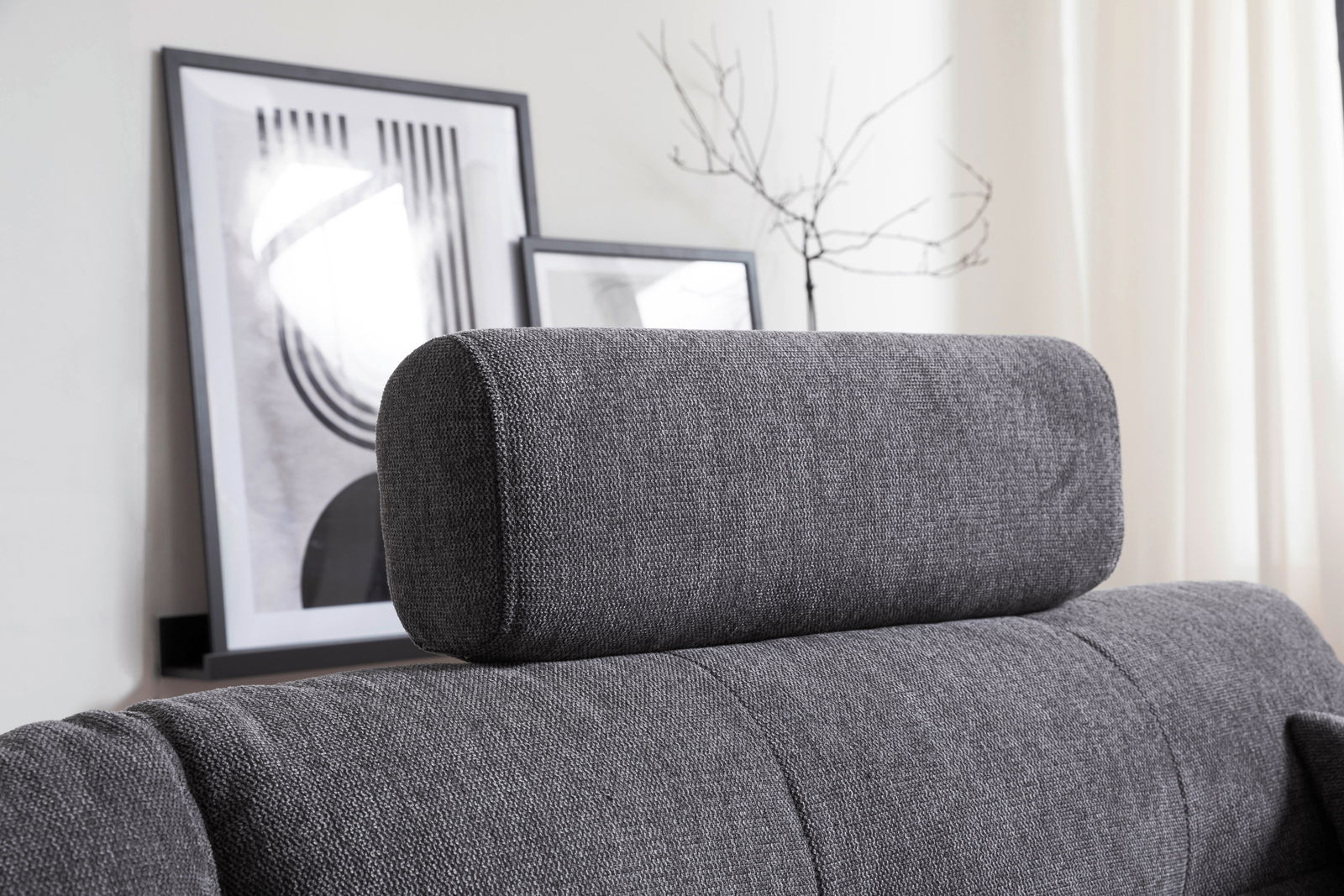 Hom´in Kopfstütze TANIKA Graue Kopfstütze auf einem Sofa, seitliche Perspektive, mit modernen Kunstwerken im Hintergrund.