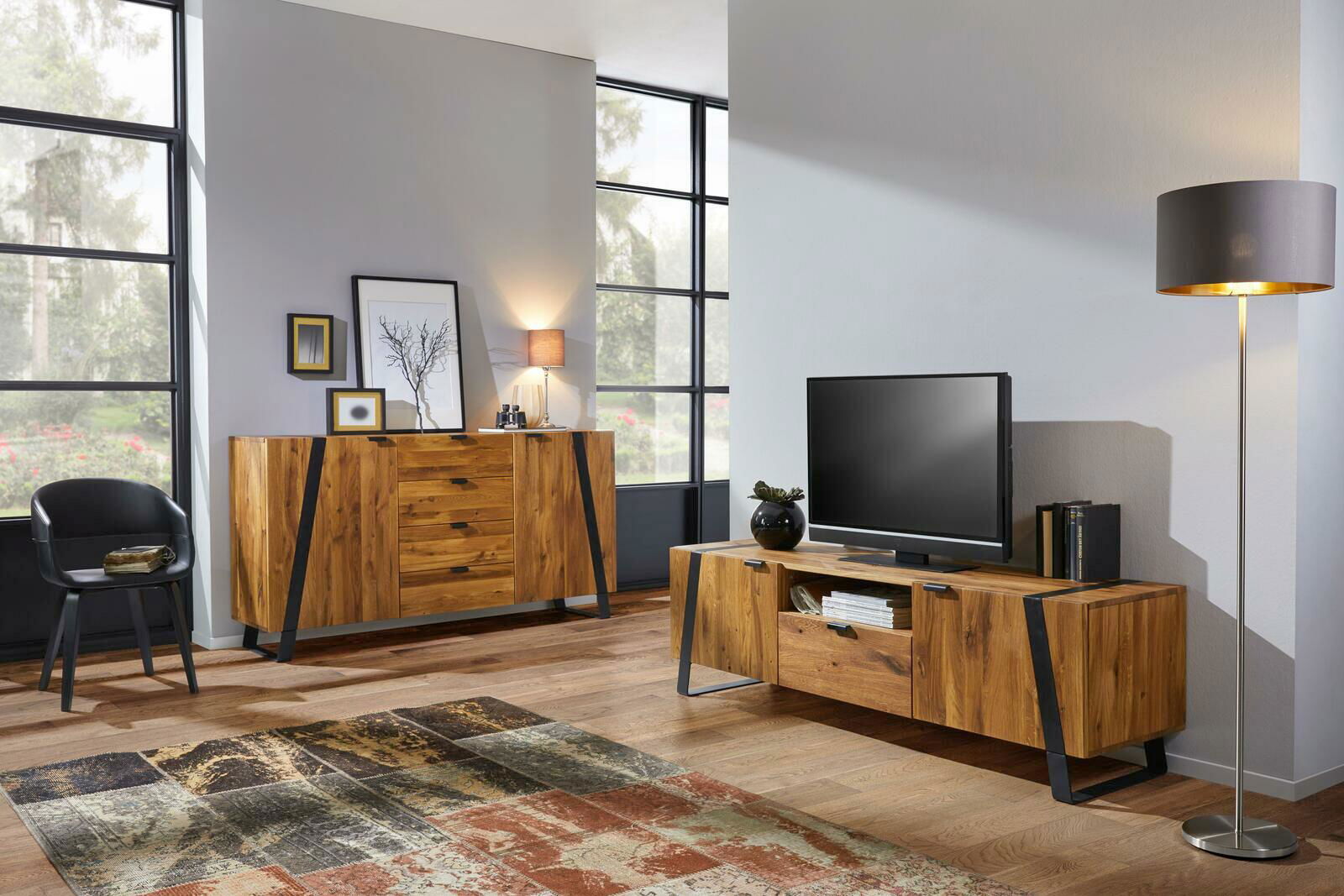 Modernes Wohnzimmer mit einem TV-Lowboard und einem Sideboard aus Holz in einer gemütlichen Einrichtung, seitliche Perspektive.