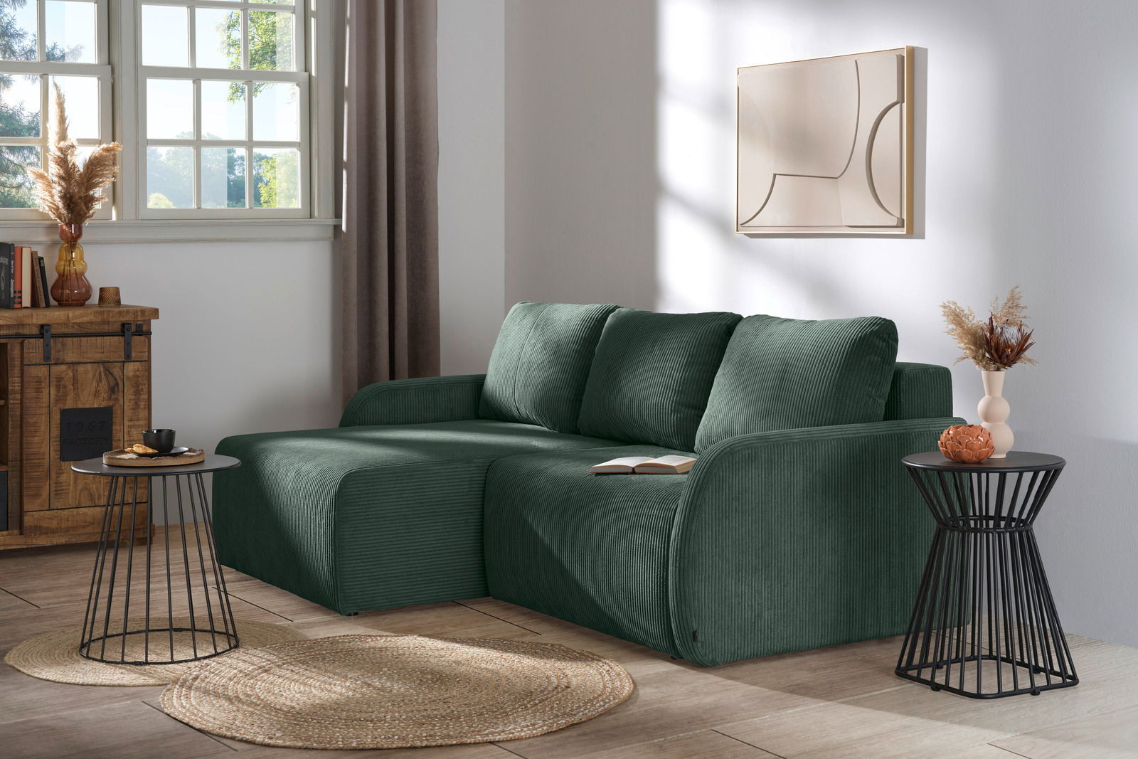 Grüne Rundecke (L) in einem modernen Wohnzimmer, seitliche Perspektive, mit dekorativen Kissen und Beistelltischen.
