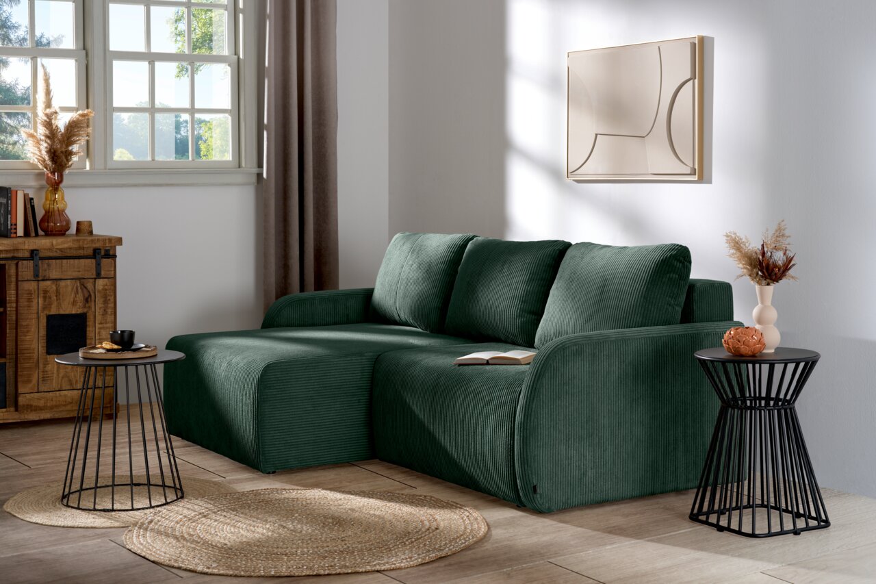 Z2 Ecksofa JENIFER Grüne Rundecke (L) in einem modernen Wohnzimmer, seitliche Perspektive, mit dekorativen Kissen und Beistelltischen.