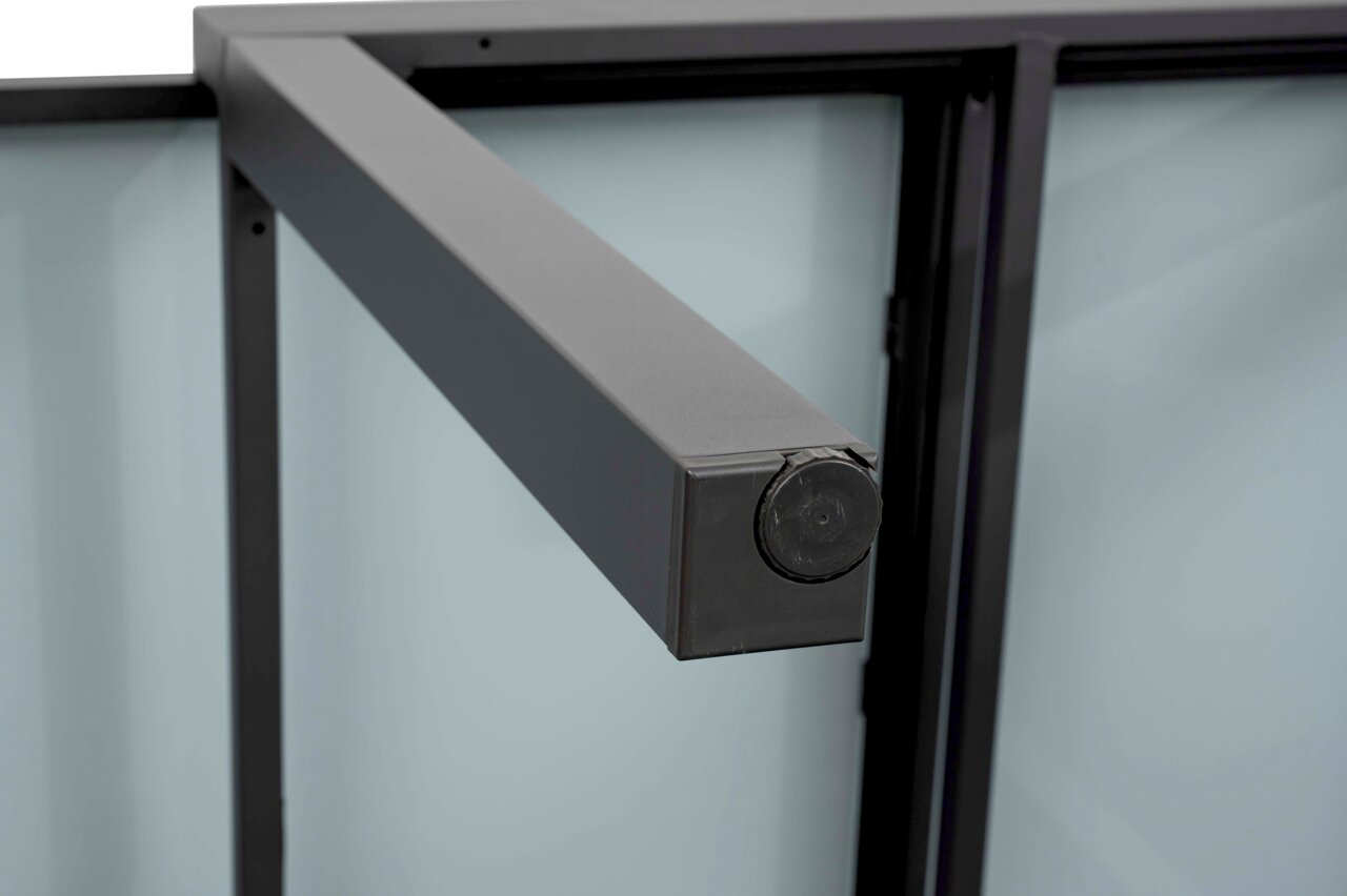 Close-up van een metalen tuintafelonderstel, gezien vanuit een zijdelingse hoek.