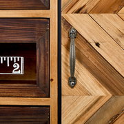 Nahaufnahme einer Kommode mit Holzmaserung und Metallgriff, perspektivisch von vorne aufgenommen.