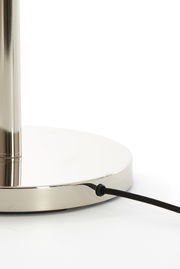 Nahaufnahme des Sockels einer Stehleuchte mit glänzender Metalloberfläche und schwarzem Kabel.