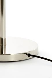 Nahaufnahme des Sockels einer Stehleuchte mit glänzender Metalloberfläche und schwarzem Kabel.