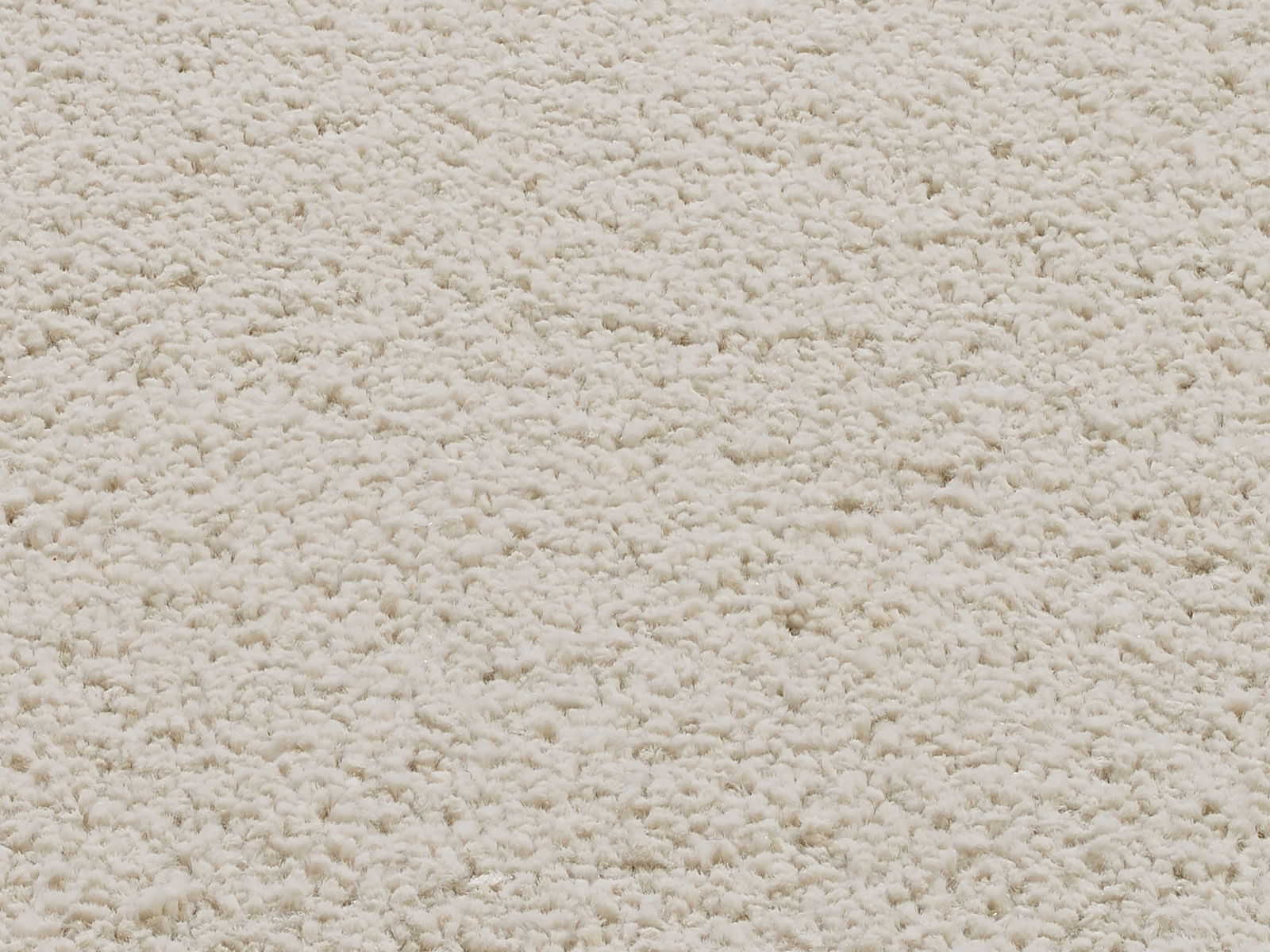 Nahaufnahme eines cremefarbenen Uni-Teppichs mit weicher, flauschiger Textur.