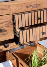 Nahaufnahme eines Servierwagens aus Holz mit geöffneten Schubladen, Weinflaschenhalter und Aufbewahrungsboxen, aus der Perspektive von vorne.