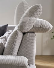 Nahaufnahme einer verstellbaren Rückenlehne eines grauen Sofas mit geripptem Stoffbezug, seitliche Perspektive